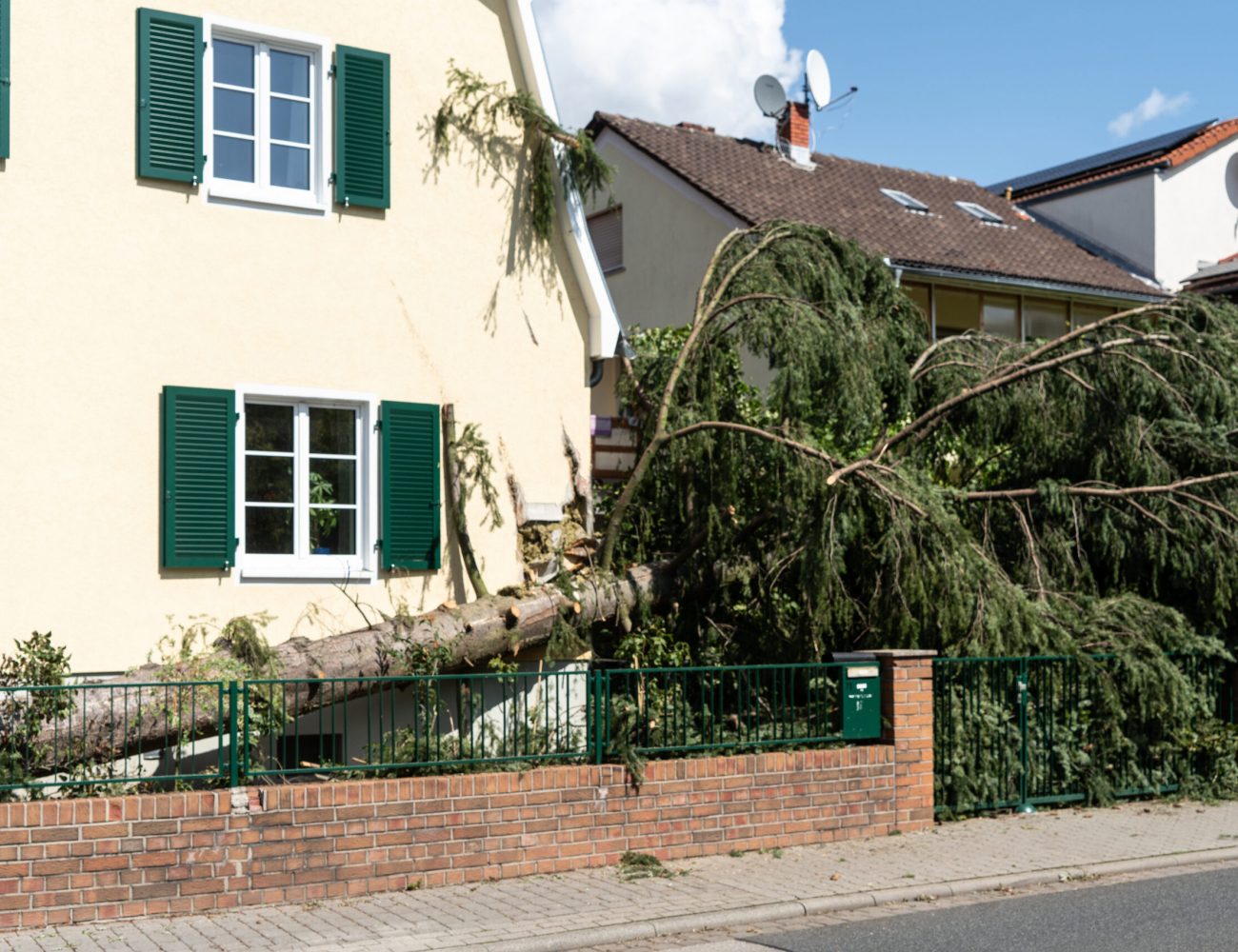 Gefällte Fichte nach Unwetter beschädigt Haus
